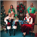 Mrs. Santa reading to Santa, two children and two adults. 