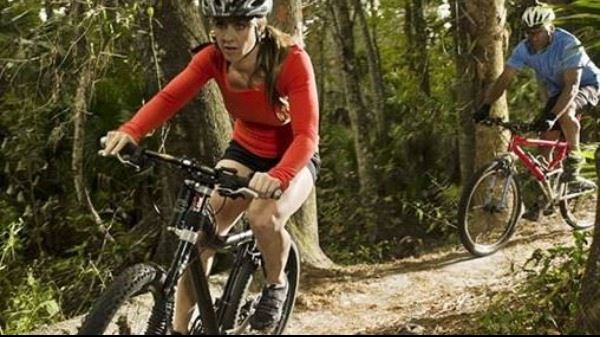 Female and male bike rider on a dirt path. 