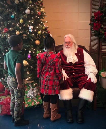 Boy and girl talking to Santa Claus.