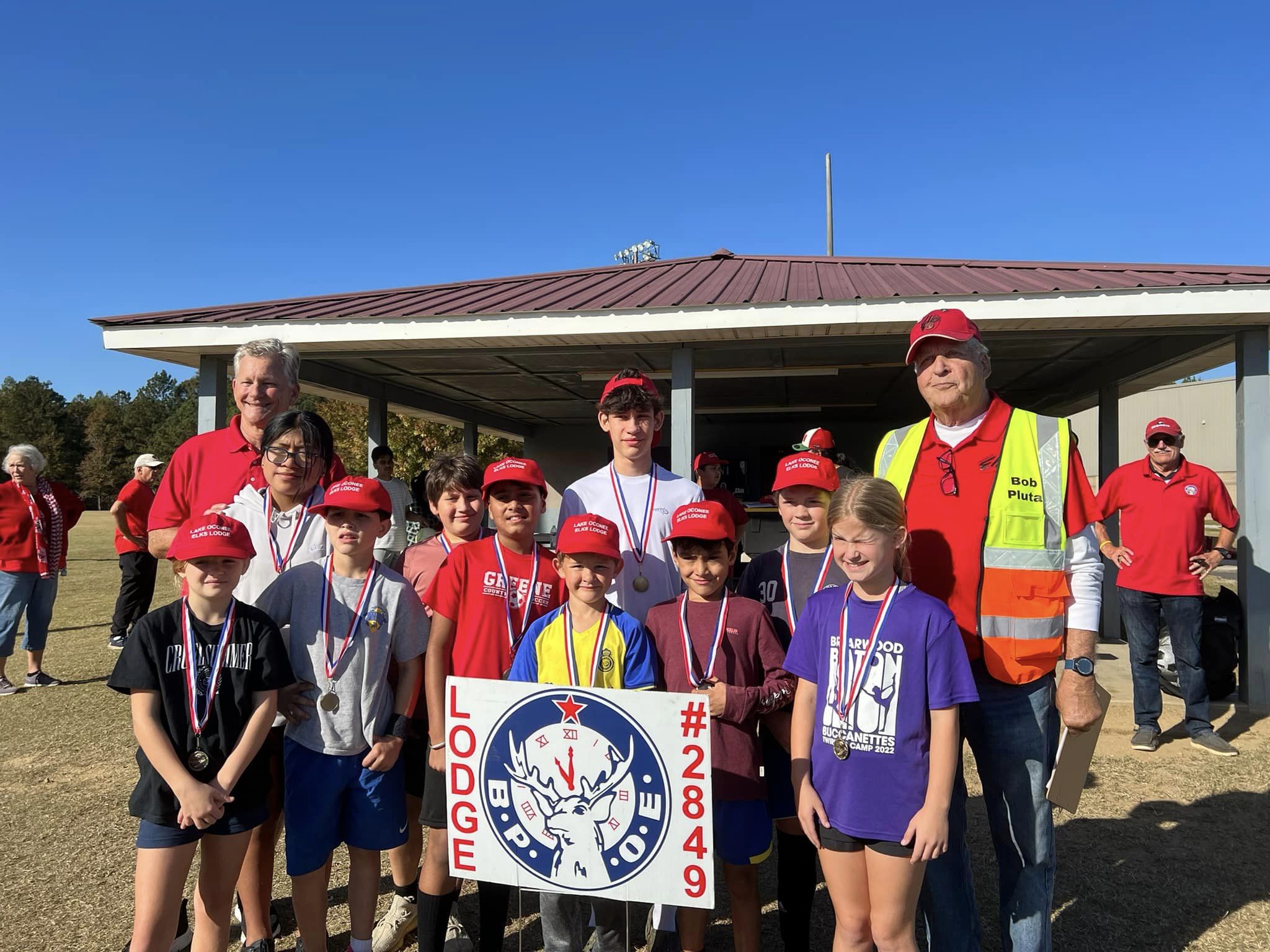 Adults and children holding an Elks Lodge sign. 