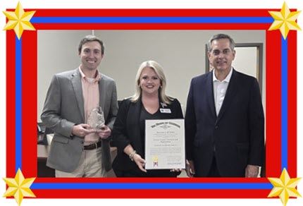 Two men and one woman holding awards
